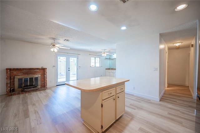 4409 Rosebank Cir, Las Vegas, NV 89108 - kitchen featuring light countertops, french doors, a ceiling fan, a kitchen island, and light wood-style flooring