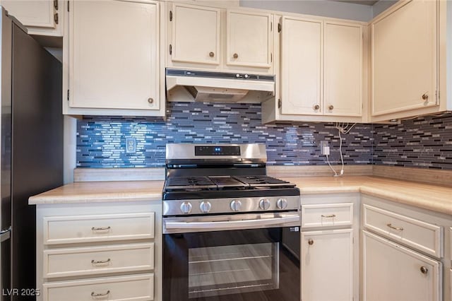 4409 Rosebank Cir, Las Vegas, NV 89108 - kitchen with stainless steel range with gas cooktop, under cabinet range hood, freestanding refrigerator, light countertops, and decorative backsplash