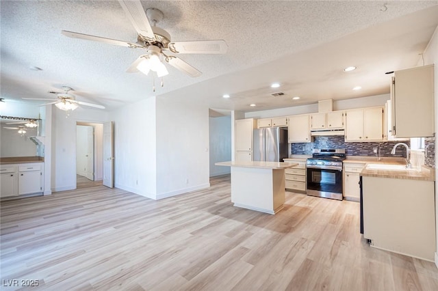 4409 Rosebank Cir, Las Vegas, NV 89108 - kitchen with stainless steel appliances, under cabinet range hood, a textured ceiling, light countertops, and a center island