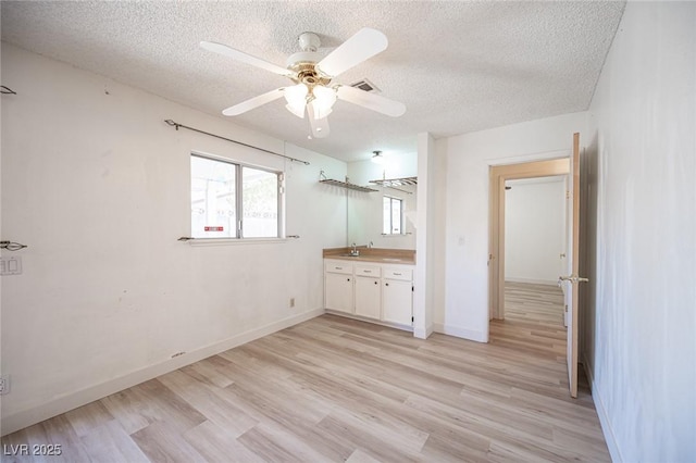 4409 Rosebank Cir, Las Vegas, NV 89108 - unfurnished bedroom featuring a textured ceiling, light wood-style flooring, baseboards, ceiling fan, and a sink