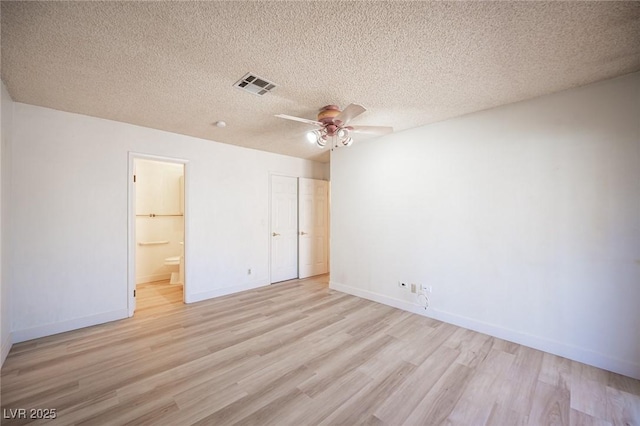 4409 Rosebank Cir, Las Vegas, NV 89108 - unfurnished bedroom featuring light wood finished floors, baseboards, ensuite bath, a closet, and a textured ceiling
