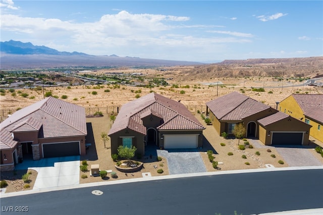 977 Majestic Vw, Mesquite, NV 89034 - view of front facade with a mountain view, a tile roof, a garage, gravel driveway, and stucco siding