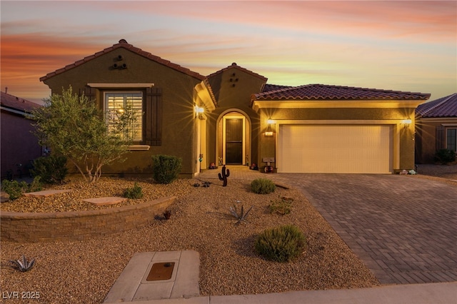 977 Majestic Vw, Mesquite, NV 89034 - mediterranean / spanish-style house with a tile roof, decorative driveway, an attached garage, and stucco siding