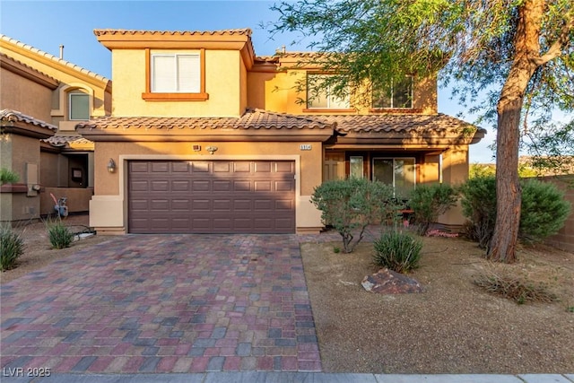 6954 Jacksboro Ct, North Las Vegas, NV 89084 - view of front facade featuring a garage, decorative driveway, stucco siding, and a tiled roof