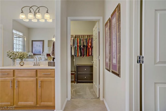 6440 Bristlebird St, North Las Vegas, NV 89084 - bathroom featuring vanity, tile patterned floors, a walk in closet, and baseboards