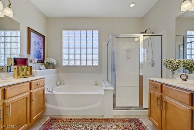 6440 Bristlebird St, North Las Vegas, NV 89084 - bathroom featuring a stall shower, two vanities, a garden tub, and recessed lighting