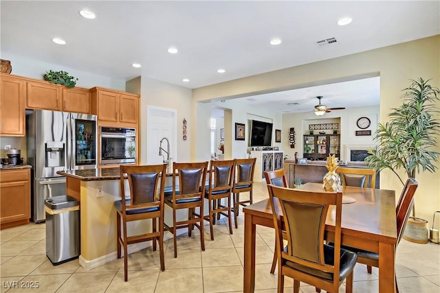 6440 Bristlebird St, North Las Vegas, NV 89084 - kitchen with stainless steel appliances, light tile patterned floors, recessed lighting, a ceiling fan, and a breakfast bar area