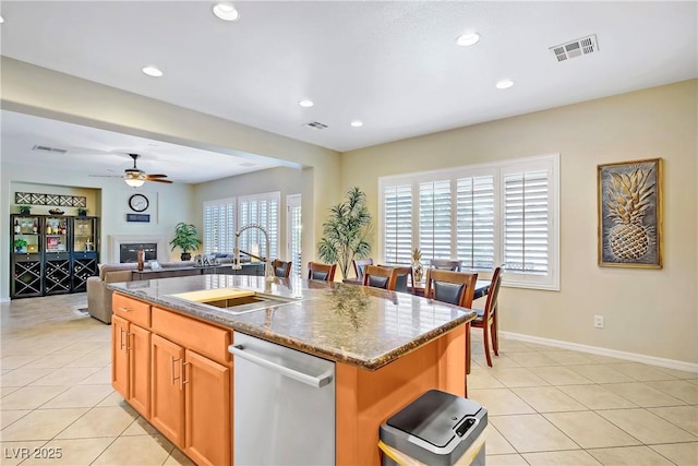 6440 Bristlebird St, North Las Vegas, NV 89084 - kitchen with stainless steel dishwasher, a sink, a kitchen island with sink, ceiling fan, and light tile patterned floors