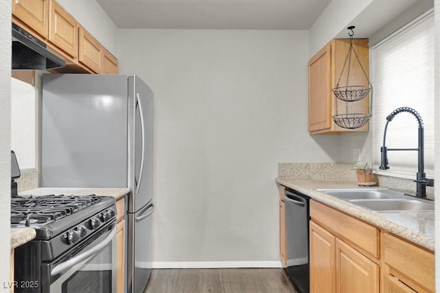 6445 Ironbark Ln, Las Vegas, NV 89107 - kitchen with stainless steel gas range oven, a sink, dishwasher, light brown cabinets, and wood finished floors