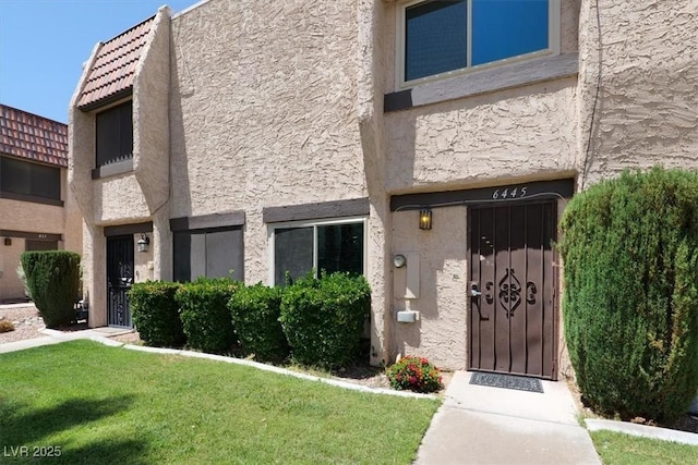 6445 Ironbark Ln, Las Vegas, NV 89107 - view of front facade with stucco siding and a front yard