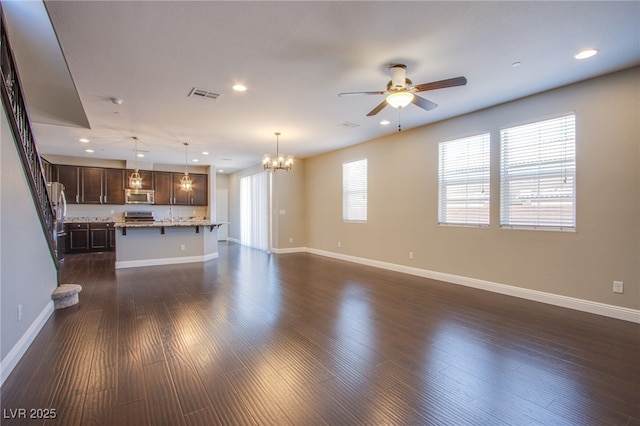 2369 Via Barranca St, Henderson, NV 89044 - unfurnished living room with a ceiling fan, a chandelier, baseboards, dark wood-type flooring, and recessed lighting