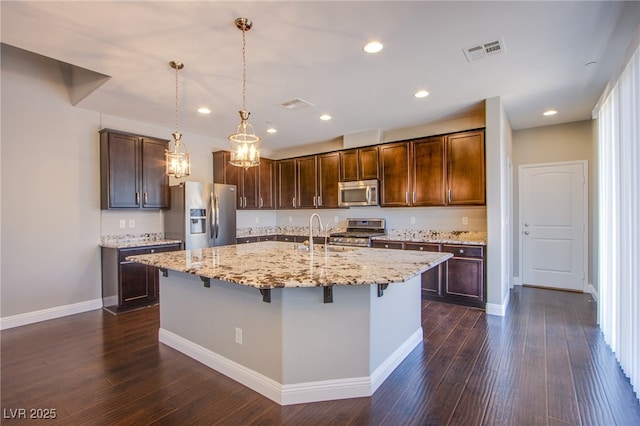 2369 Via Barranca St, Henderson, NV 89044 - kitchen featuring appliances with stainless steel finishes, light stone counters, dark wood-style floors, dark brown cabinetry, and recessed lighting