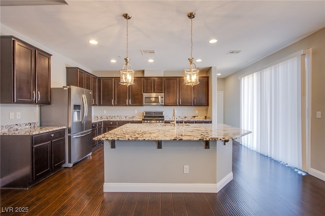 2369 Via Barranca St, Henderson, NV 89044 - kitchen with stainless steel appliances, dark brown cabinetry, light stone countertops, dark wood-style flooring, and recessed lighting
