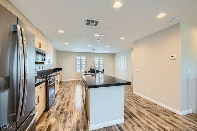 9050 W Tropicana Ave Unit 1015, Las Vegas, NV 89147 - kitchen featuring stainless steel appliances, a sink, dark countertops, wood finished floors, and recessed lighting