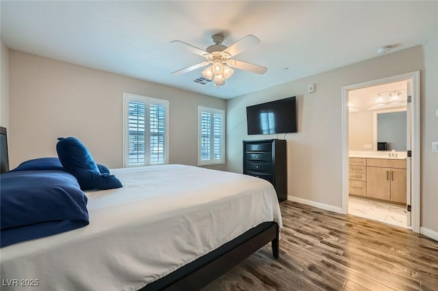 9050 W Tropicana Ave Unit 1015, Las Vegas, NV 89147 - bedroom with wood finished floors, baseboards, connected bathroom, and ceiling fan