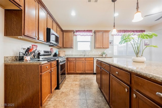 132 Soaring Sky Ave, Henderson, NV 89011 - kitchen with appliances with stainless steel finishes, light stone countertops, decorative light fixtures, brown cabinets, and a sink