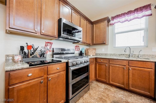 132 Soaring Sky Ave, Henderson, NV 89011 - kitchen featuring appliances with stainless steel finishes, a sink, brown cabinets, light stone countertops, and light tile patterned floors