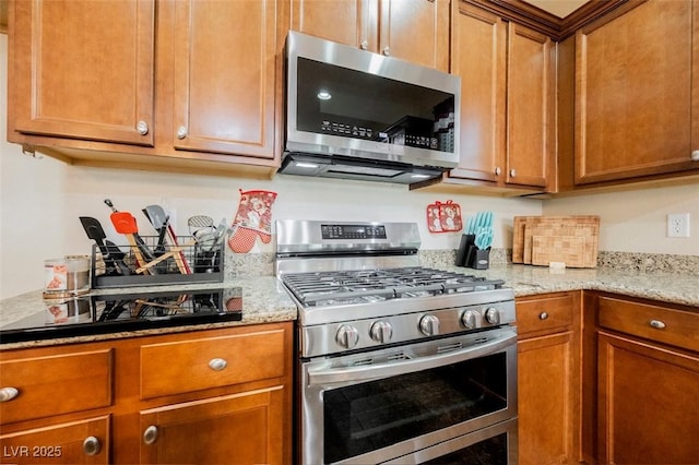132 Soaring Sky Ave, Henderson, NV 89011 - kitchen with appliances with stainless steel finishes, brown cabinetry, and light stone countertops