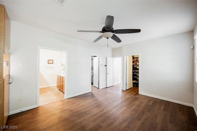 132 Soaring Sky Ave, Henderson, NV 89011 - unfurnished bedroom with wood finished floors, a walk in closet, baseboards, and connected bathroom