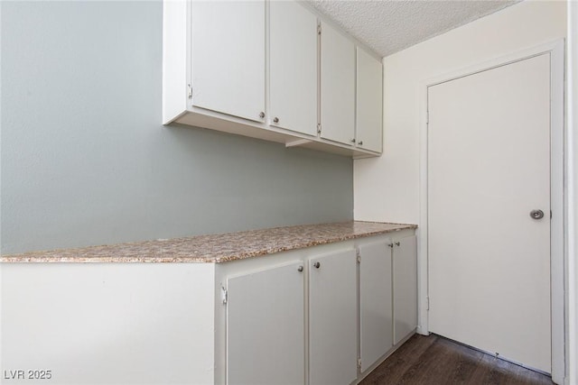 5523 Orchard Ln Unit 0, Las Vegas, NV 89110 - kitchen with a textured ceiling, white cabinetry, light countertops, and dark wood-style flooring