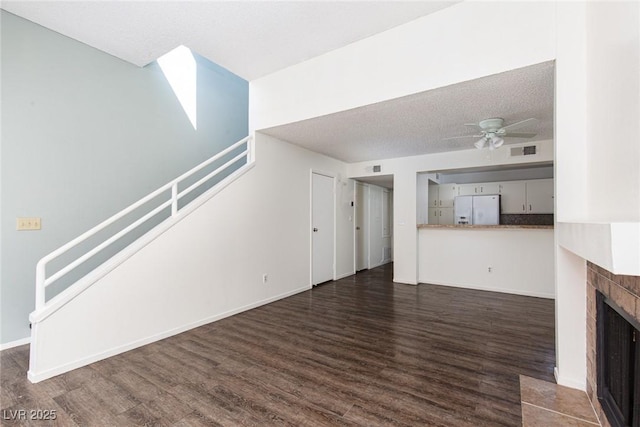 5523 Orchard Ln Unit 0, Las Vegas, NV 89110 - unfurnished living room with dark wood-type flooring, stairs, ceiling fan, a tile fireplace, and baseboards