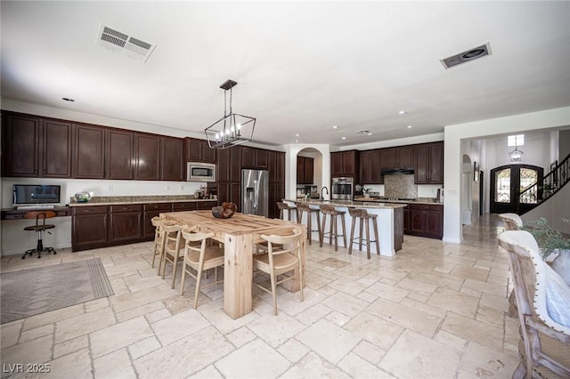 7538 Mustang St, Las Vegas, NV 89131 - dining room with stone tile floors, arched walkways, recessed lighting, and a chandelier