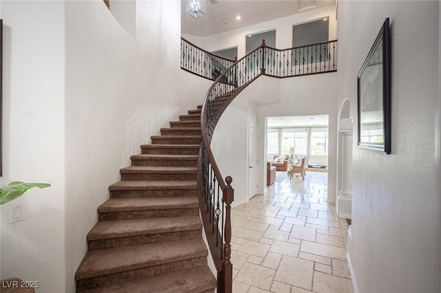7538 Mustang St, Las Vegas, NV 89131 - staircase featuring a towering ceiling, stone tile flooring, and baseboards