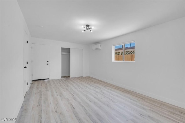 1115 W Nelson Ave, North Las Vegas, NV 89030 - unfurnished bedroom featuring a wall mounted AC, light wood-style floors, a closet, and baseboards