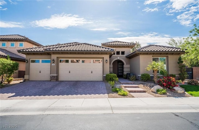 2896 Grande Arch St, Henderson, NV 89044 - mediterranean / spanish-style house featuring stucco siding, decorative driveway, a garage, and a tiled roof