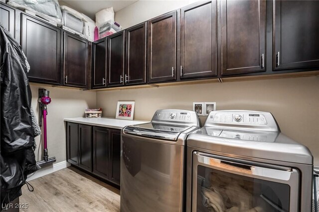 2896 Grande Arch St, Henderson, NV 89044 - laundry area featuring washing machine and clothes dryer, cabinet space, and light wood-type flooring