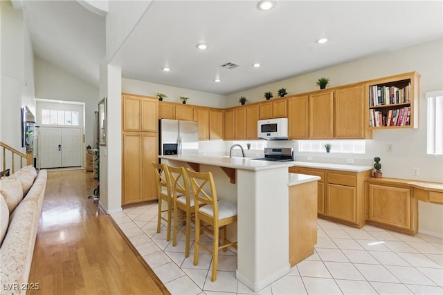 9785 Turtle Head Ct, Las Vegas, NV 89117 - kitchen featuring stainless steel appliances, light countertops, a sink, a kitchen breakfast bar, and an island with sink