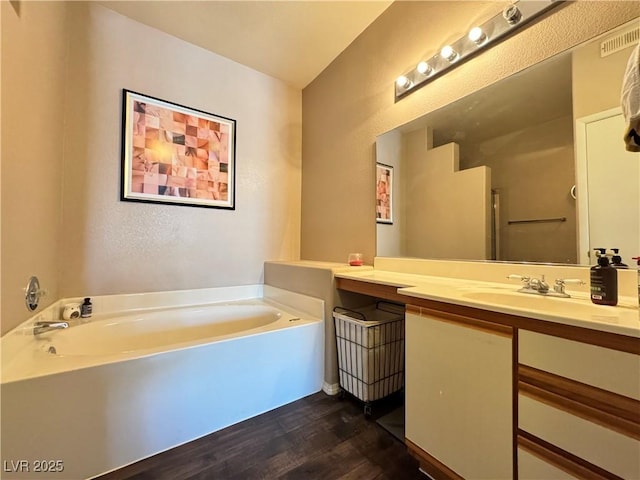 5750 E Hacienda Ave Unit 107, Las Vegas, NV 89122 - bathroom with wood finished floors, vanity, and a garden tub