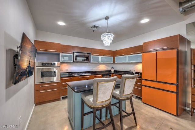900 Las Vegas Blvd Unit 1208, Las Vegas, NV 89101 - kitchen with stainless steel appliances, dark countertops, a breakfast bar, a chandelier, and pendant lighting