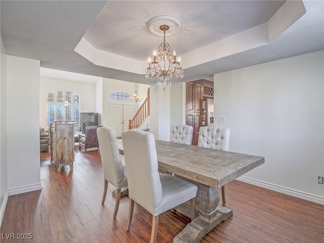 2732 Dune Cove Rd, Las Vegas, NV 89117 - dining space featuring a chandelier, a tray ceiling, wood finished floors, and baseboards