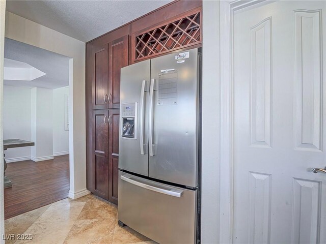 2732 Dune Cove Rd, Las Vegas, NV 89117 - kitchen featuring stainless steel fridge with ice dispenser, baseboards, and dark brown cabinets
