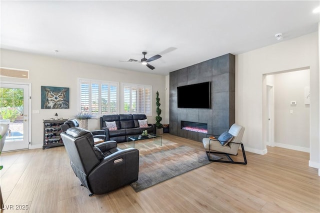 10504 Button Willow Dr, Las Vegas, NV 89134 - living room featuring light wood finished floors, baseboards, a ceiling fan, and a fireplace