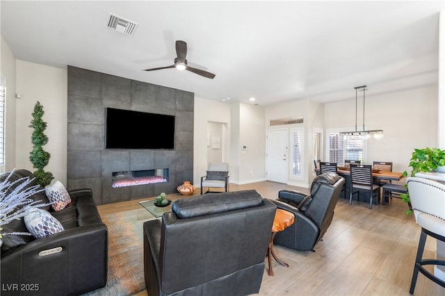 10504 Button Willow Dr, Las Vegas, NV 89134 - living area with a fireplace, healthy amount of natural light, ceiling fan, and light wood finished floors