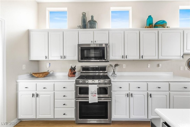10504 Button Willow Dr, Las Vegas, NV 89134 - kitchen featuring stainless steel appliances, white cabinetry, light countertops, and plenty of natural light
