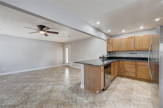 839 Benita Pl, Boulder City, NV 89005 - kitchen with appliances with stainless steel finishes, a peninsula, baseboards, dark stone countertops, and open floor plan