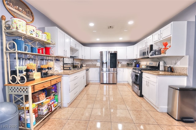 1112 Sandy Cove St, Las Vegas, NV 89110 - kitchen with stainless steel appliances, a sink, light tile patterned floors, white cabinetry, and recessed lighting