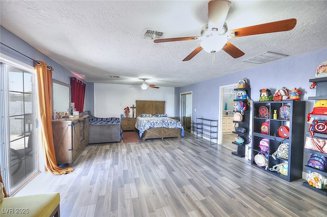 1112 Sandy Cove St, Las Vegas, NV 89110 - bedroom with light wood-style floors, a textured ceiling, and a ceiling fan