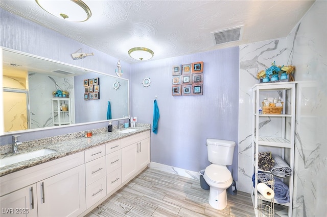 1112 Sandy Cove St, Las Vegas, NV 89110 - full bathroom featuring toilet, double vanity, wood tiled floors, and baseboards