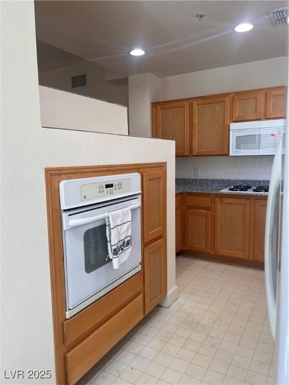 87 E Agate Ave Unit 202, Las Vegas, NV 89123 - kitchen with white appliances, recessed lighting, and brown cabinetry