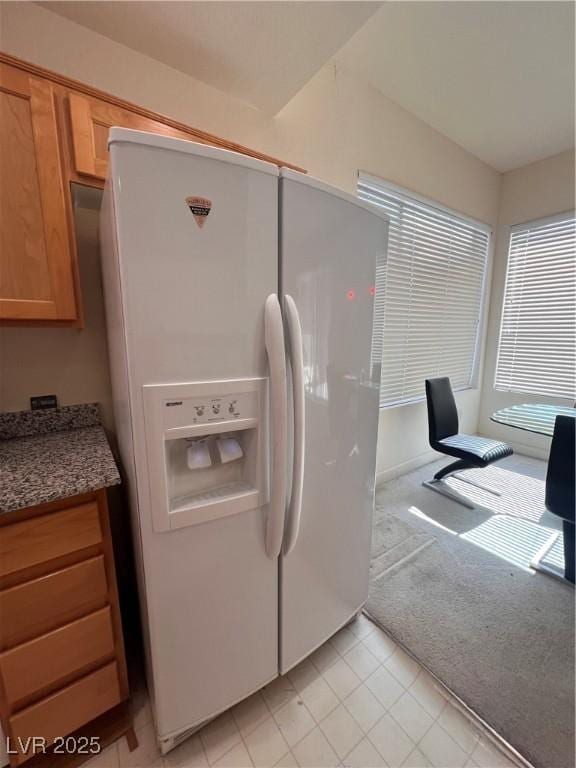 87 E Agate Ave Unit 202, Las Vegas, NV 89123 - kitchen with white refrigerator with ice dispenser, light tile patterned floors, light carpet, and light stone counters