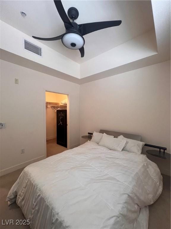87 E Agate Ave Unit 202, Las Vegas, NV 89123 - carpeted bedroom featuring a tray ceiling, a spacious closet, baseboards, a ceiling fan, and a closet