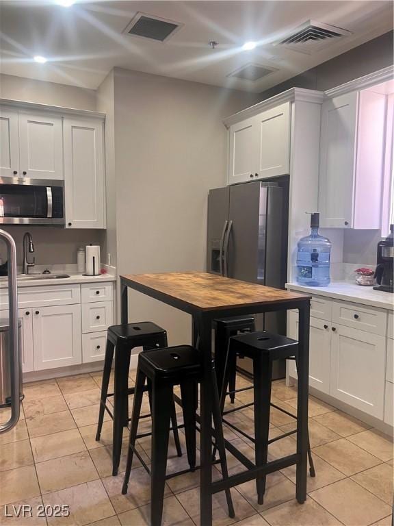 87 E Agate Ave Unit 202, Las Vegas, NV 89123 - kitchen featuring appliances with stainless steel finishes, light tile patterned flooring, and white cabinets