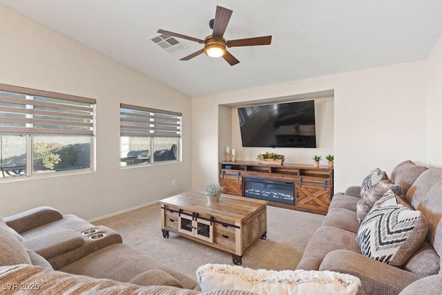 1079 Oak Shade Ln, Henderson, NV 89015 - carpeted living area with vaulted ceiling, ceiling fan, baseboards, and a glass covered fireplace