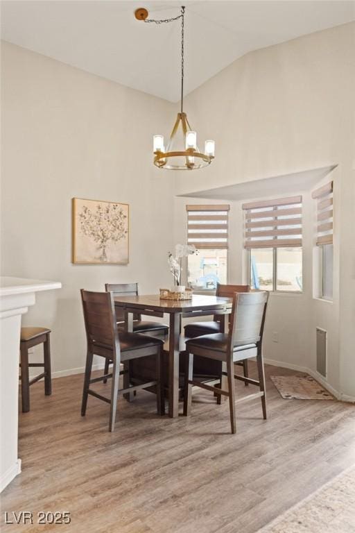 1079 Oak Shade Ln, Henderson, NV 89015 - dining space featuring a chandelier, vaulted ceiling, wood finished floors, and baseboards