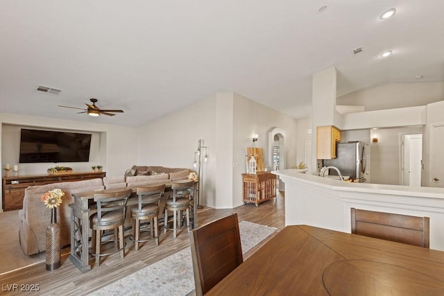 1079 Oak Shade Ln, Henderson, NV 89015 - dining room featuring lofted ceiling, wood finished floors, ceiling fan, arched walkways, and recessed lighting