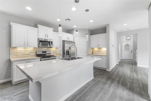 2231 Desert Prairie St, Las Vegas, NV 89135 - kitchen with appliances with stainless steel finishes, baseboards, tasteful backsplash, a kitchen island with sink, and white cabinetry